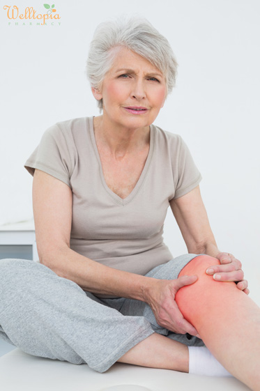 senior woman with painful knee sitting examination table